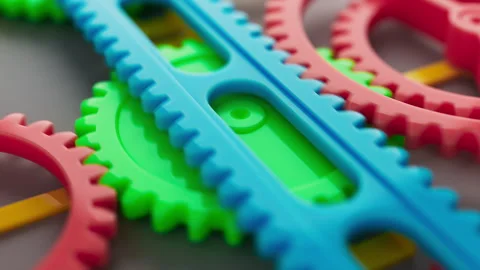 Looped animation of a group of multi-colored children plastic gears. Stock Footage 273920350