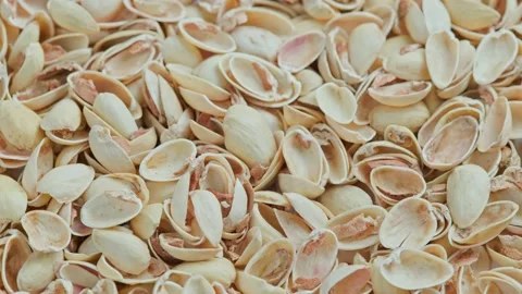 Looped rotating empty pistachios shells full frame close-up background Video stock 164171178