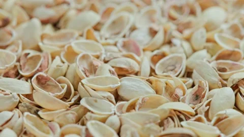 Looped rotating empty pistachios shells full frame close-up background Video stock 164353435