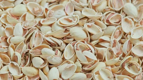 Looped rotating empty pistachios shells full frame close-up background Video stock 164529715