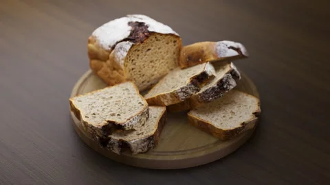 Looping animation around a composition of loaf cake lying on a wooden board. Video stock 312576329