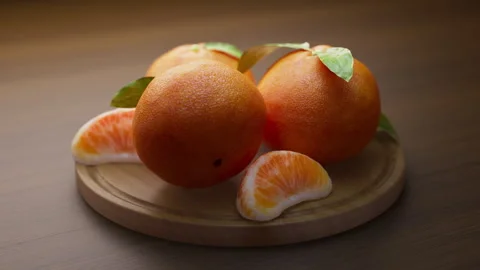 Looping animation around a composition of tangerines lying on a wooden board. Stock Footage 315528172