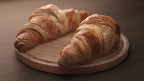 Looping animation around a composition of two croissants lying on a wooden board Stock Footage 312108703