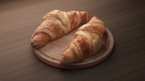 Looping animation around a composition of two croissants lying on a wooden board Stock Footage 312576252