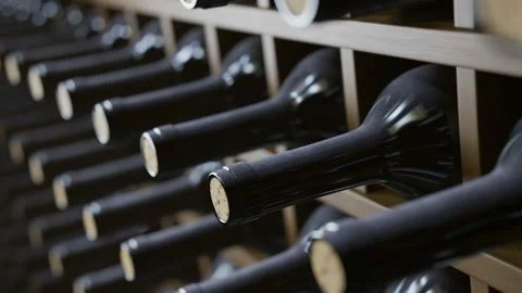 Looping animation of wine bottles ordered on wooden shelves in dark wine-cellar. Stock Footage 163545684