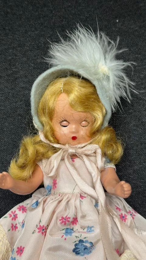 Looping blinking blonde hair bisque vintage doll isolated on black fabric 動画素材 343323294