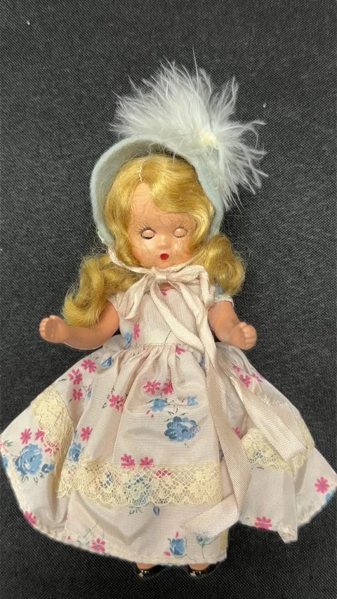 Looping blinking blonde hair bisque vintage doll isolated on black fabric Stockbeeldmateriaal 343323298