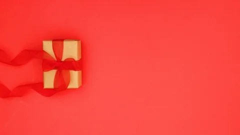 Looping gift box with red ribbon run on red background - Stop motion Video stock 123142868