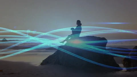 Looping glowing blue ribbons guiding woman shifting into squat atop coastal rock Stock Footage 310670193