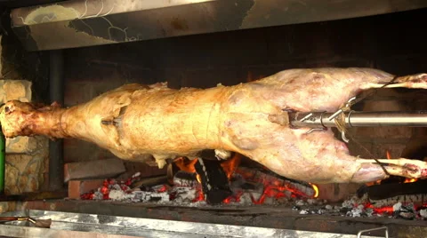 Looping - A whole lamb roasts over a fire on a spit Stock Footage 40101276