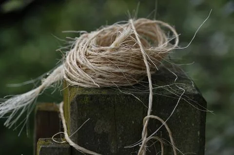 A loose ball of string has been left on a wooden garden fence post Stockfoto's