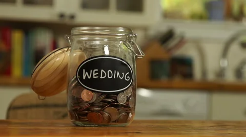 Loose change put in a saving jar, reading Wedding Stock Footage 44116847