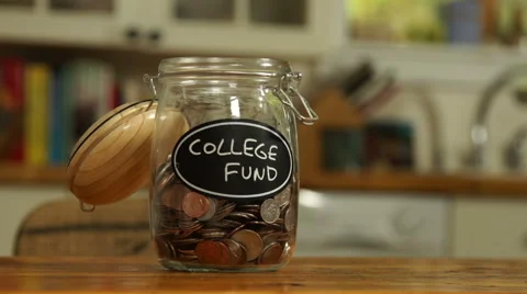 Loose change put in a saving jar, reading College Fund Video stock 44116854