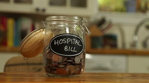 Loose change put in a saving jar, reading Hospital Bill Stock Footage 44116861