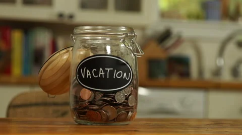 Loose change put in a saving jar, reading Vacation Stock Footage 44116928