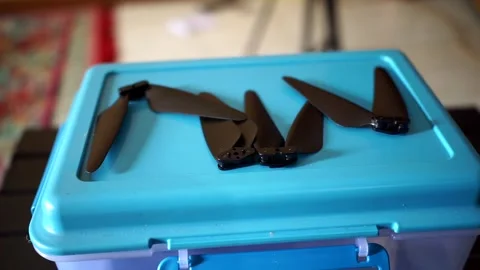 Loose foldable drone propeller blades displayed on a blue container, Video stock 323304266