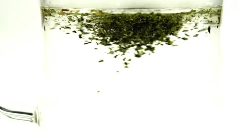 Loose leaf green tea dissolving in boiling hot water in slow motion Stock Footage 45027929