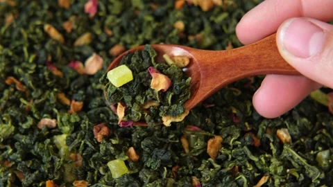Loose Leaf Mango Pineapple Fruit Tea Wallpaper. Wooden spoon picks up dry tea Stock Footage 242005972