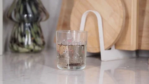 Loose leaf tea brewing inside glass cup with floral pattern on white kitche.. Stock Footage 331924761