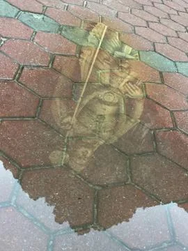 Lord Murugan Statue reflected in a puddle Stock Photos