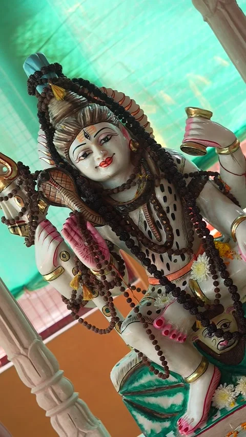 Lord Shiva Statue Holding Trident and Pot in Temple Decorated with Beads an.. Stock Footage 320362917
