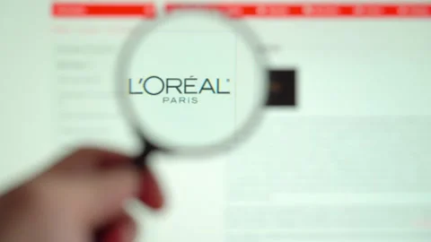 LOREAL on logo is visible on the display screen through a magnifying glass. Vidéo 153100285