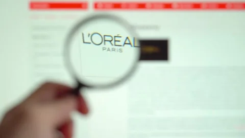 LOREAL on logo is visible on the display screen through a magnifying glass. Stock Footage 153100323