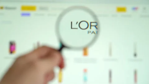 LOREAL on logo is visible on the display screen through a magnifying glass. Stock Footage 153100484