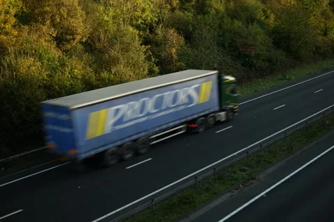 Lorries pass autumn trees in UK 6K Video stock 290349403