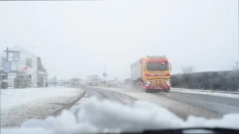 Lorries passing car in winter snow york united kingdom Stock Footage 147733650