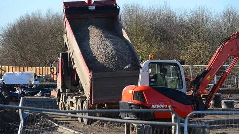 Lorry driver tipping aggregate from trailer on building site uk Stock Footage 86233553