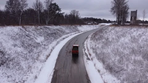 Lorry drives along road between hills with bare trees Video stock 166576283