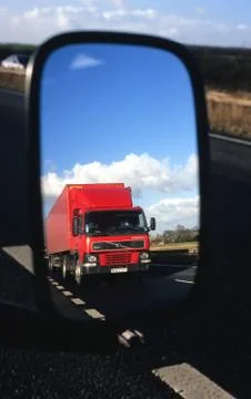 Lorry reflected in vehicle wing mirror travelling on motorway uk Stock Photos