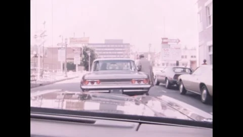 LOS ANGELES - 1975 - A policeman pulls over a woman for cutting off a bus in Los Stock Footage 338027514