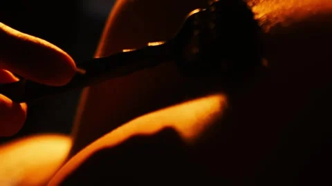 Lose-up of BDSM needle wheel rolling on female body part covered in oil. Stock Footage 313107112