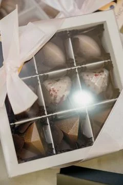 Lose-up of a gift box with candy in the shape of hearts and pyramids. Stock Photos