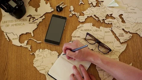 Lose-up man writes in his notebook the plan of his travels. Travel agency, tour Stock Footage 93028798