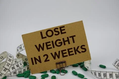 Lose Weight In 2 Weeks text with medicine, alarm clock and measuring tape o.. Stock Photos