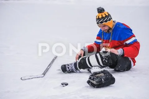 Loser hockey player sitting on the ice one Stock Photos