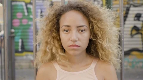 Lost and confused young Hispanic woman portrait near ruined shops in the city Stock Footage 80657320