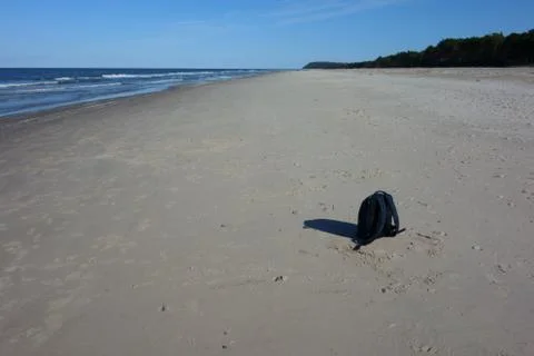 Lost backpack on an empty beach Stock Photos