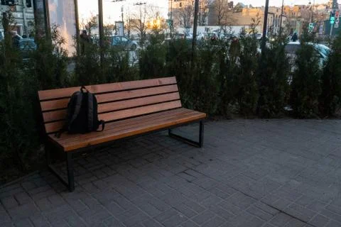 A lost backpack lying on a park bench. Stock Photos