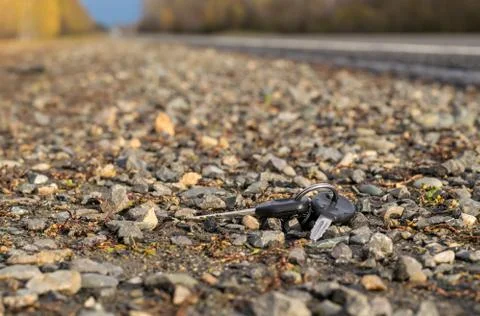 Lost bunch of keys lying on the side of the road near the asphalt pavement Stock Photos