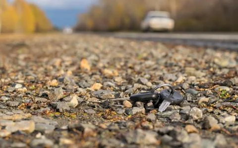 Lost bunch of keys lying on the side of the road near the asphalt pavement Stock Photos