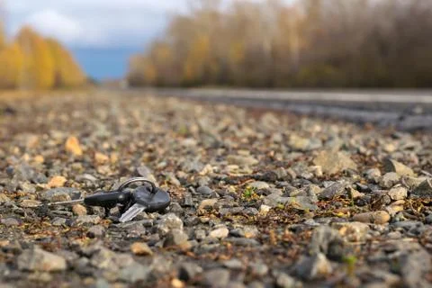 Lost bunch of keys lying on the side of the road near the asphalt pavement Stock Photos