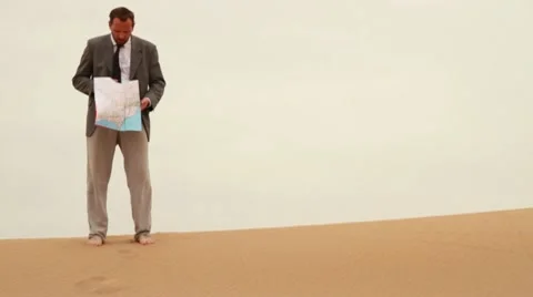 Lost businessman looking at map in the desert HD Video stock 10709342