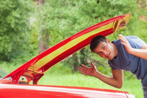 Lost handsome man checking his car engine Stock Photos