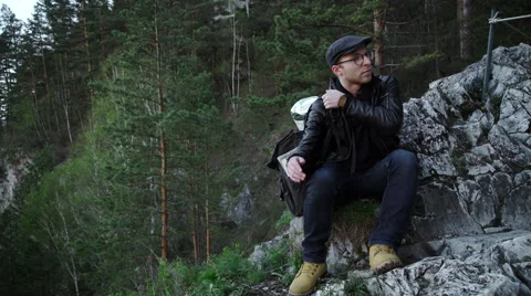 Lost hiker with backpack checks map to find directions in wilderness area Stock Footage 63384072