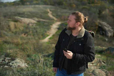 Lost hiker with smartphone looking for direction on the steeppe .Concept of p Stock Photos