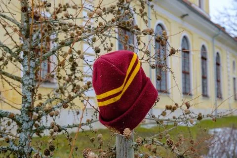 Lost knitted wool hat in dark red. hung in a visible place near the building. Foto stock